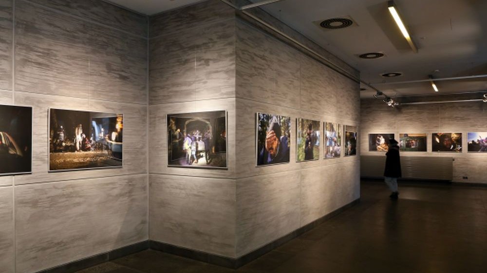 The picture of the Grand Lobby in Zamek Culture Centre, where the exhibition is displayed: several photos on the walls. - grafika artykułu
