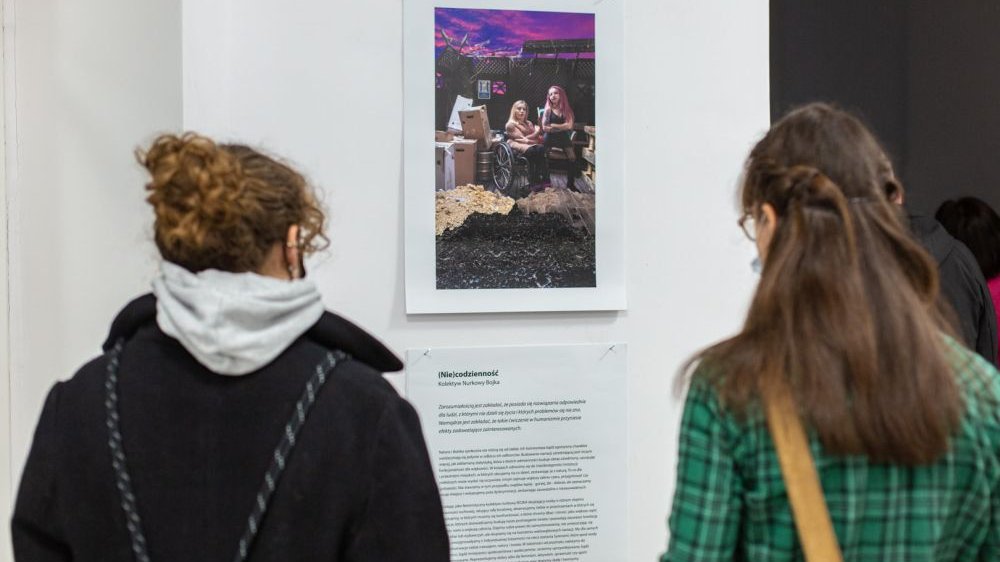 Photo from the exhibition: two women watching one of the works