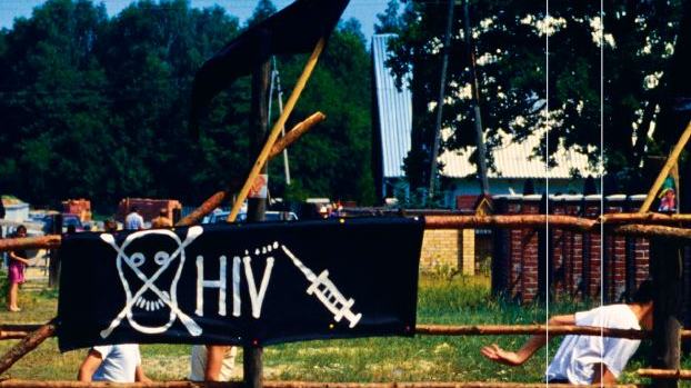 Okładka, na której widać chłopców grających bestrosko w piłkę, na płocie wisi czarny plakat z napisem "HIV" oraz narysowaną czaszką i strzykawką.
